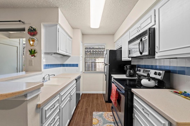 9226 Jollyville Rd Unit 170, Austin, TX 78759 - kitchen featuring appliances with stainless steel finishes, a sink, a textured ceiling, tasteful backsplash, and light countertops