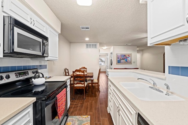9226 Jollyville Rd Unit 170, Austin, TX 78759 - kitchen with stainless steel appliances, a sink, white cabinetry, light countertops, and a textured ceiling