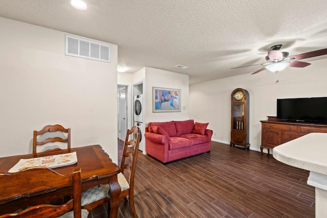 9226 Jollyville Rd Unit 170, Austin, TX 78759 - dining space with stacked washing machine and dryer, a ceiling fan, dark wood finished floors, baseboards, and a textured ceiling