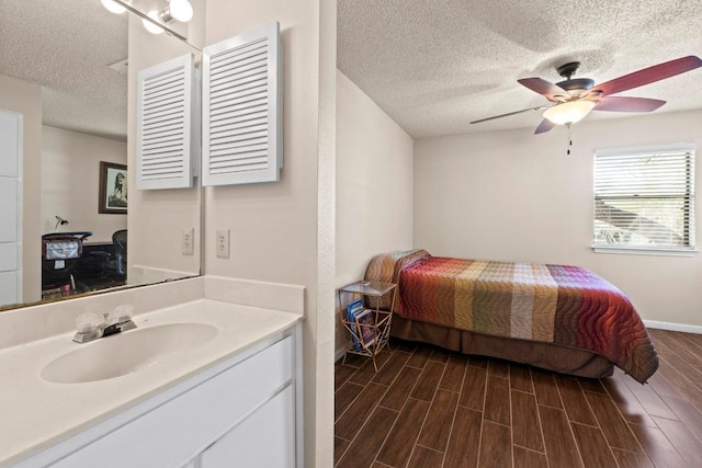 9226 Jollyville Rd Unit 170, Austin, TX 78759 - bedroom featuring a textured ceiling, a sink, dark wood-style floors, baseboards, and a ceiling fan