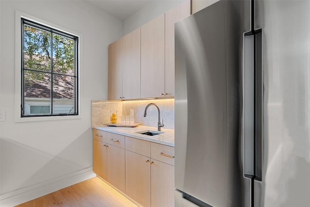 2209 Bowman Ave, Austin, TX 78703 - kitchen featuring freestanding refrigerator, a sink, baseboards, tasteful backsplash, and light wood-style floors