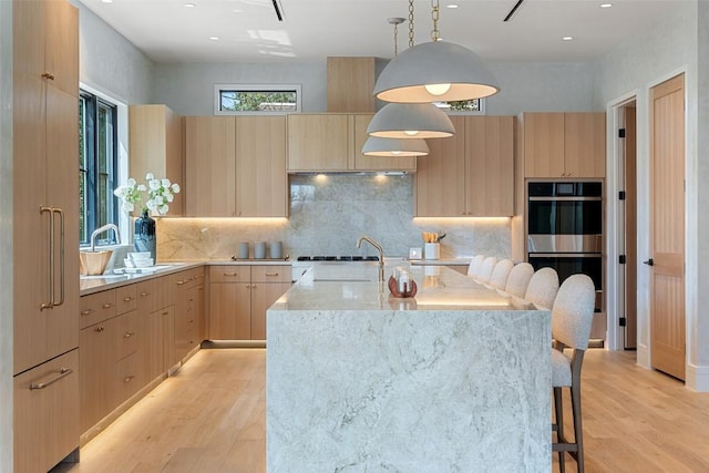2209 Bowman Ave, Austin, TX 78703 - kitchen with light brown cabinets, modern cabinets, double oven, light wood-style floors, and recessed lighting