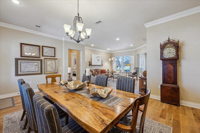 dining area featuring light wood-style flooring, visible vents, baseboards, and an inviting chandelier