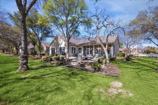 back of house with a patio and a lawn