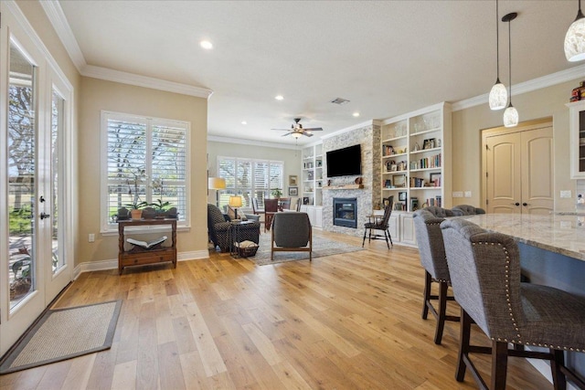 interior space with a large fireplace, baseboards, recessed lighting, light wood-style flooring, and ceiling fan