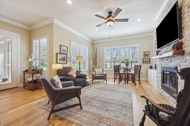 living room featuring baseboards, a stone fireplace, ceiling fan, light wood-style floors, and recessed lighting