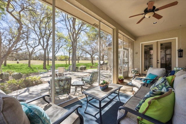 sunroom / solarium featuring french doors, ceiling fan, and an outdoor hangout area