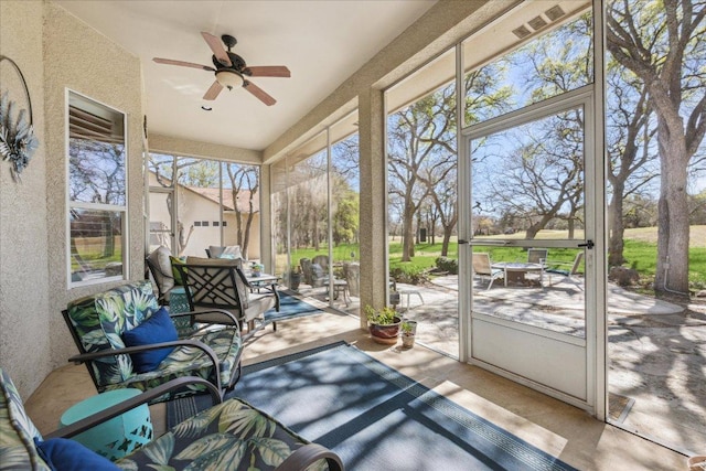 sunroom / solarium featuring an outdoor fire pit and a ceiling fan