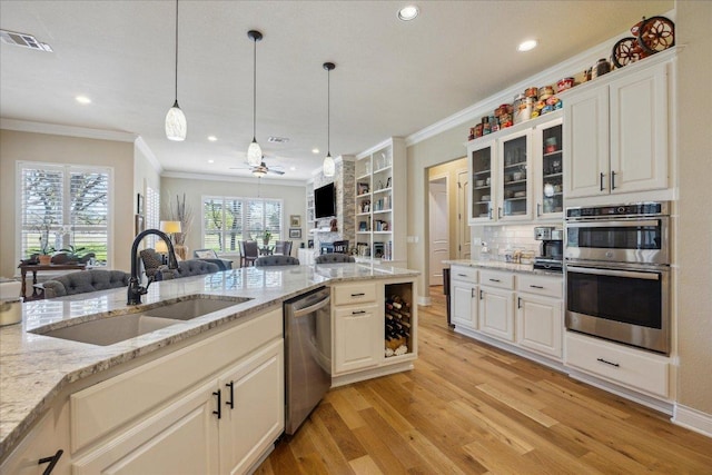 kitchen featuring open floor plan, light wood-style floors, visible vents, appliances with stainless steel finishes, and a sink