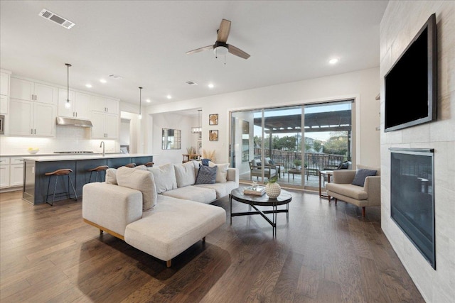 19302 Summit Glory Trl Unit 68, Spicewood, TX 78669 - living area with dark wood finished floors, a tiled fireplace, recessed lighting, and ceiling fan