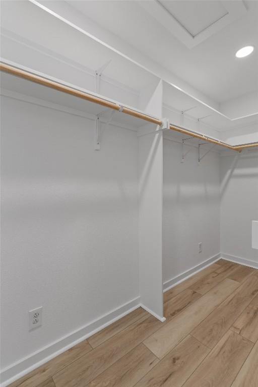 walk in closet with wood finished floors
