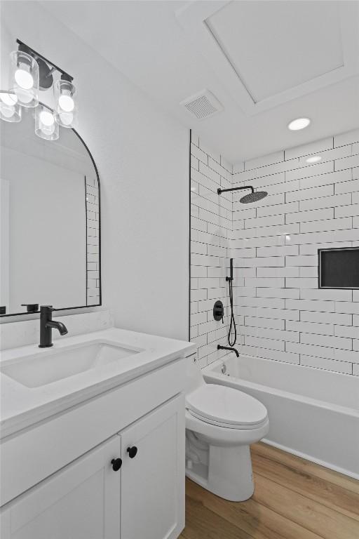 full bathroom with vanity, wood finished floors, visible vents, toilet, and shower / bathtub combination