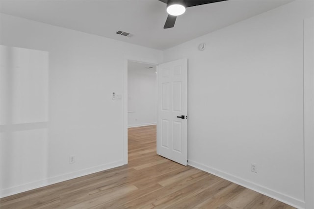 spare room with light wood-type flooring, baseboards, visible vents, and ceiling fan
