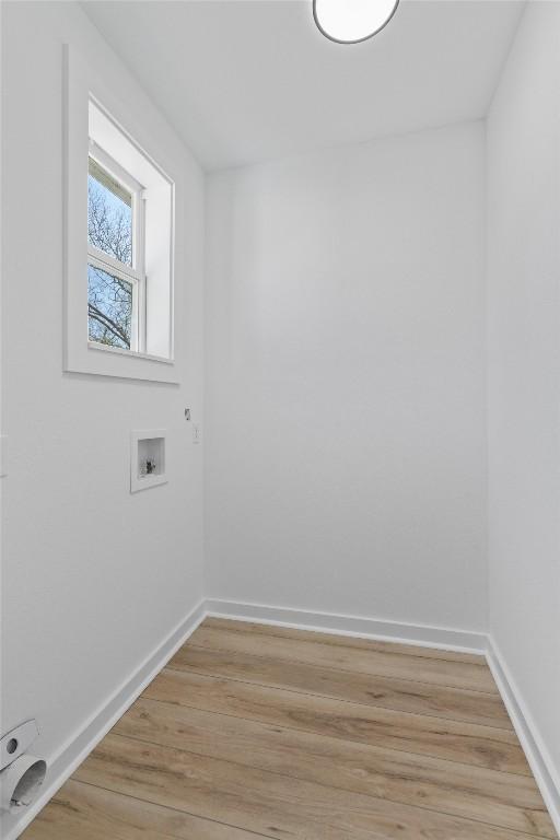 laundry area with washer hookup, laundry area, light wood-style floors, and baseboards