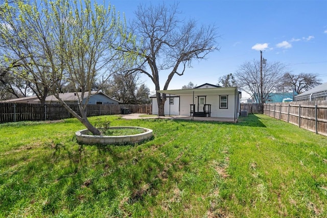 rear view of property with a yard, a fenced backyard, and a patio area