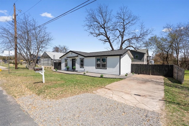 view of front of property with a front yard, driveway, and fence