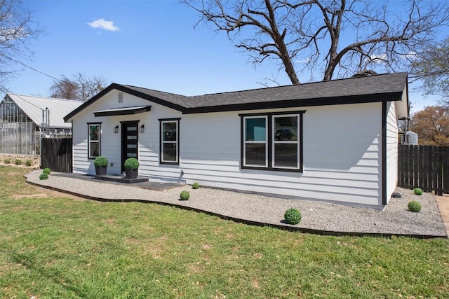 single story home with a front lawn and fence