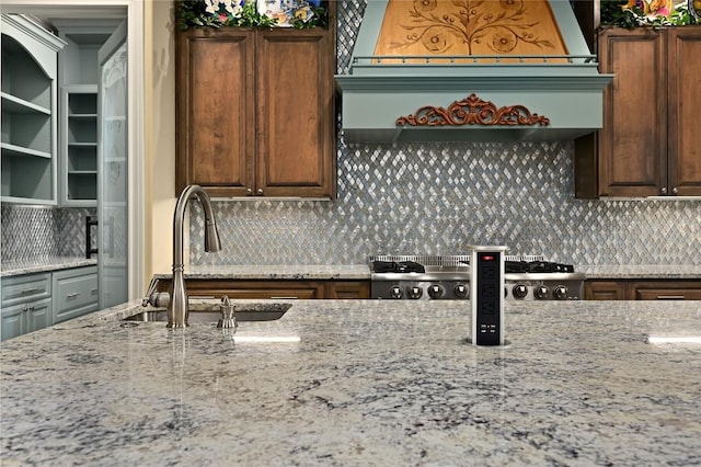 2624 University Club Dr, Austin, TX 78732 - kitchen with decorative backsplash, custom range hood, light stone counters, and a sink