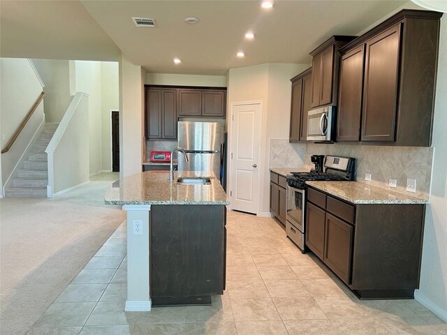 4413 Shady Hill Ln, Pflugerville, TX 78660 - kitchen with stainless steel appliances, dark brown cabinetry, light stone countertops, backsplash, and recessed lighting