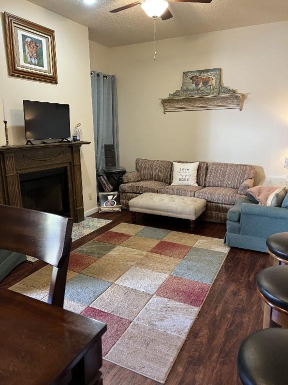 2905 Swisher St Unit 207, Austin, TX 78705 - living room featuring a ceiling fan, wood finished floors, a fireplace, and a textured ceiling