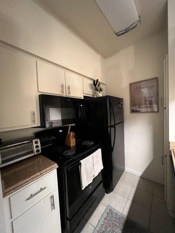 2905 Swisher St Unit 207, Austin, TX 78705 - kitchen with black appliances, light tile patterned flooring, and white cabinets