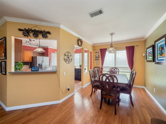 16501 Spotted Eagle Dr, Leander, TX 78641 - dining area with light wood-type flooring and crown molding