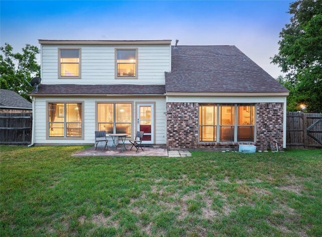 16501 Spotted Eagle Dr, Leander, TX 78641 - back of house with a fenced backyard, a patio area, roof with shingles, and brick siding
