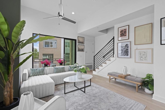 living area with ceiling fan, recessed lighting, baseboards, wood finished floors, and stairway