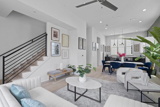 living room with recessed lighting, a ceiling fan, light wood finished floors, and stairway