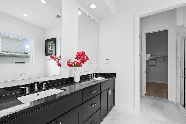 full bathroom with double vanity, baseboards, recessed lighting, and a sink