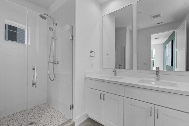 full bathroom with a sink, a stall shower, and visible vents