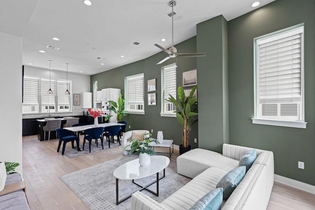 living room with light wood-style floors, baseboards, recessed lighting, and visible vents