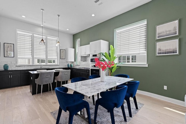 dining room featuring light wood-style floors, baseboards, recessed lighting, and visible vents