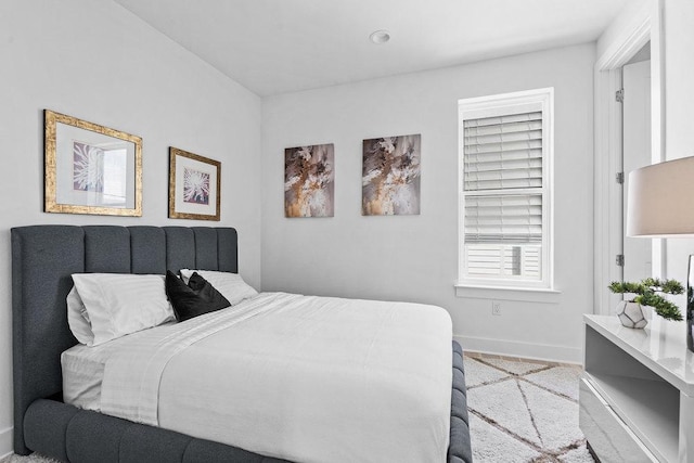 bedroom with baseboards and light carpet