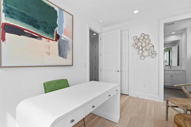 office space with recessed lighting, baseboards, visible vents, and light wood finished floors