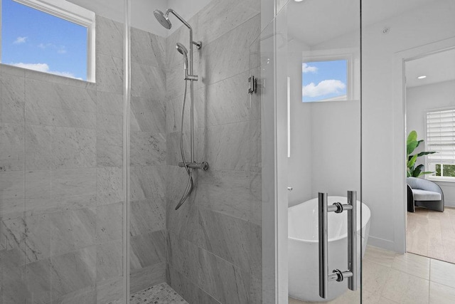 bathroom with a tile shower and a soaking tub