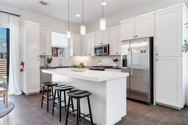 1126 Linden St Unit 1, Austin, TX 78702 - kitchen featuring appliances with stainless steel finishes, a kitchen breakfast bar, decorative backsplash, a center island, and recessed lighting