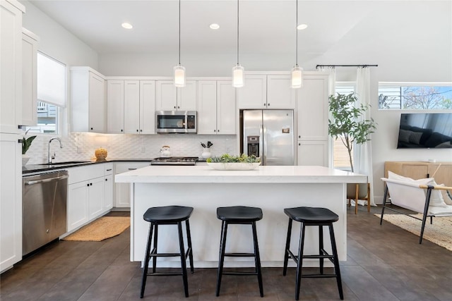 1126 Linden St Unit 1, Austin, TX 78702 - kitchen featuring appliances with stainless steel finishes, a sink, a breakfast bar area, decorative backsplash, and recessed lighting
