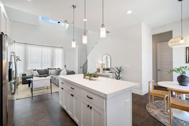 1126 Linden St Unit 1, Austin, TX 78702 - kitchen featuring stainless steel refrigerator with ice dispenser, white cabinets, light countertops, a kitchen island, and a towering ceiling