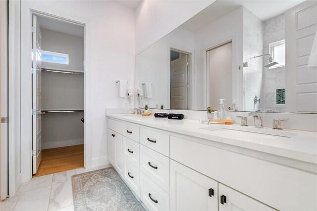 1126 Linden St Unit 1, Austin, TX 78702 - bathroom with double vanity, a tile shower, marble look tiles, baseboards, and a walk in closet