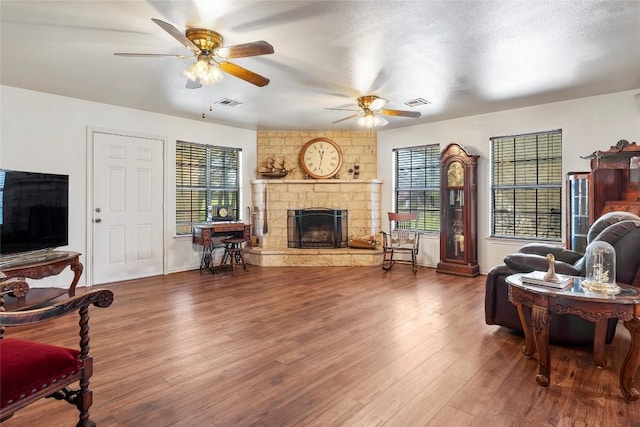 491 Herron Trl, Mcdade, TX 78650 - living room featuring a fireplace, a ceiling fan, and wood finished floors