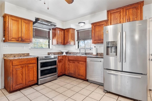 491 Herron Trl, Mcdade, TX 78650 - kitchen with stainless steel appliances, exhaust hood, brown cabinetry, and a ceiling fan