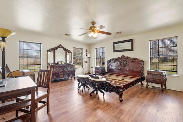 491 Herron Trl, Mcdade, TX 78650 - bedroom with wood finished floors, a textured ceiling, baseboards, and a ceiling fan