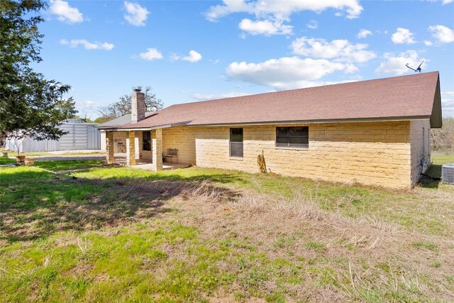 491 Herron Trl, Mcdade, TX 78650 - rear view of property featuring a chimney, central AC unit, stone siding, a patio area, and a lawn
