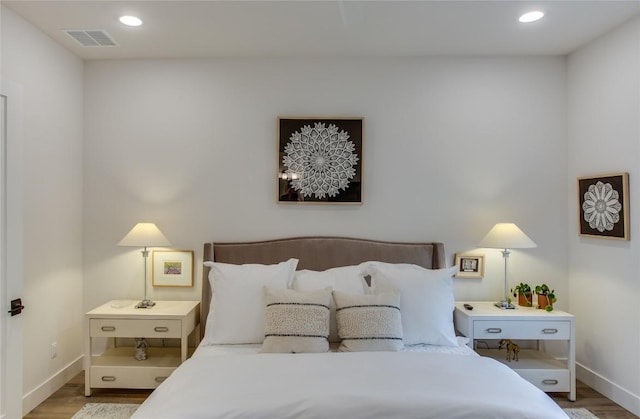 bedroom featuring recessed lighting, visible vents, baseboards, and wood finished floors