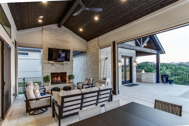 view of patio with an outdoor living space with a fireplace and ceiling fan