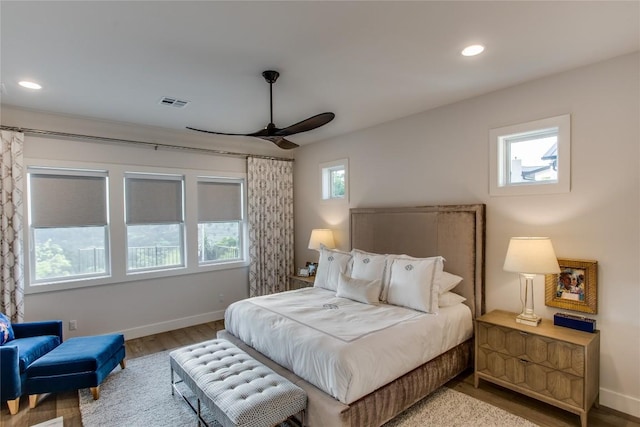 bedroom with recessed lighting, wood finished floors, visible vents, and baseboards