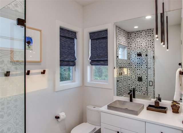 bathroom featuring vanity, a shower stall, toilet, and recessed lighting