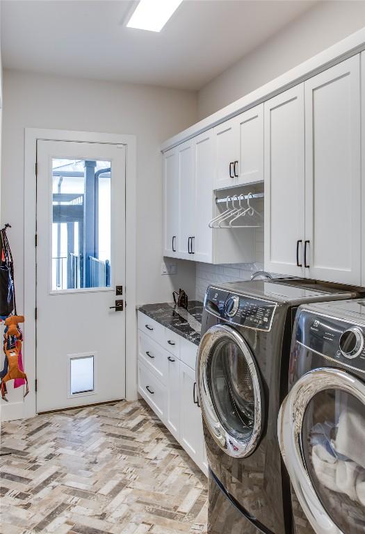 clothes washing area featuring cabinet space and washing machine and dryer