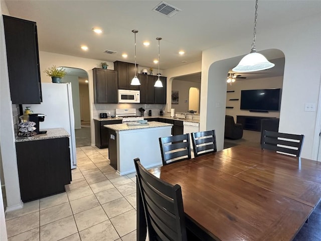 1208 Ravenside Cv, Leander, TX 78641 - dining room with arched walkways, ceiling fan, and light tile patterned floors